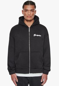 Schwarze Zip-Hoodie aus weichem Stoff; mit einer Fronttasche und einer Kapuze. "Dropsize"-Logo in Weiß auf der linken Brustseite.