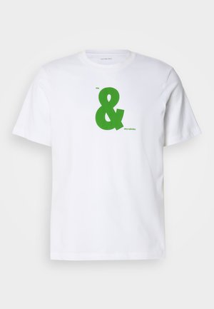 Camiseta blanca de algodón con un gran gráfico de ampersand verde, con el texto "me" en la parte superior y "mis calvins" en una fuente más pequeña en la parte inferior.