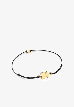 Pulsera de cordón negro con un charm en forma de nube en tono dorado y textura suave. Cierre ajustable con acentos metálicos.