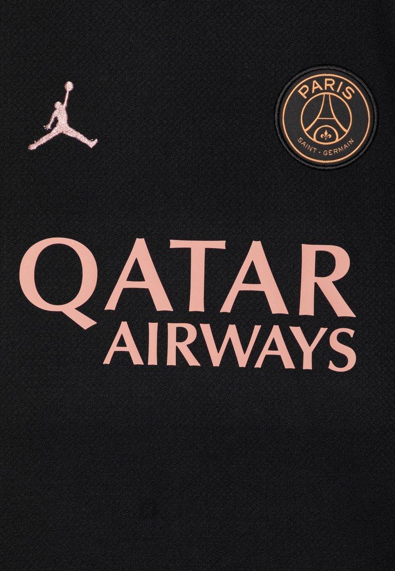 Zwarte jersey met een roze "QATAR AIRWAYS" logo, een zwart en gouden ronde PSG-embleem en een klein roze Jumpman-logo. Geweven materiaal.