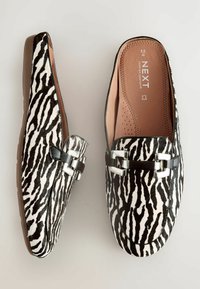 Schwarz-weiße Zebramuster-Slipper mit einem glänzenden schwarzen Akzent und silbernem Zubehör, ausgestattet mit einer glatten Lederinnensohle.
