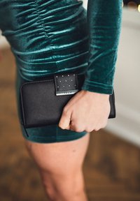 Černá kožená peněženka s texturovaným povrchem, se skládaným krytem a kovovou sponou s logem "VUCH".