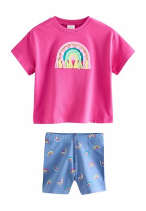 Pink kortærmet skjorte med broderet regnbue og frynser kombineret med blå shorts med flerfarvet trykt regnbuemønster.