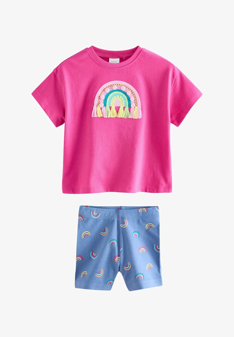 Chemise rose à manches courtes avec arc-en-ciel brodé et pompons, associée à un short bleu avec un motif arc-en-ciel imprimé multicolore.