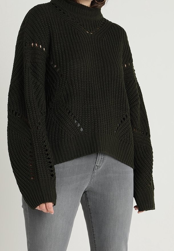 Pull en maille vert foncé avec un col montant, des épaules tombantes et des détails en point ouvert. Il présente une coupe décontractée et des poignets et ourlet côtelés.