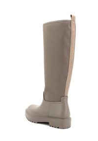Stivali in gomma al ginocchio di colore taupe, con suola testurizzata, cuciture sottili e un pull tab a contrasto con il marchio sulla parte posteriore.