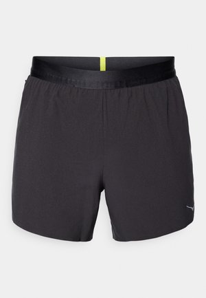 Schwarze Sportshorts mit glatter Textur, einem elastischen Taillenbund mit gelbem Akzent und einem kleinen Logo auf der unteren rechten Seite.