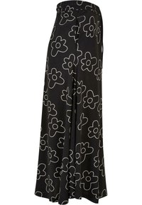 Black floral skirt featuring a bold white flower pattern, elastic waistband, flowy design, and lightweight fabric. Suitable for casual wear.