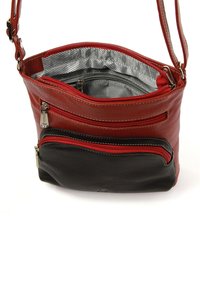 Red and black leather crossbody bag with multiple zipped pockets, textured surface, gray striped lining, and adjustable strap.