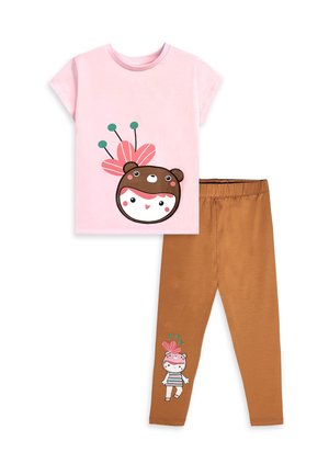 T-shirt rose à manches courtes avec un visage d'ours et un motif floral, associé à un legging marron présentant un petit personnage avec un chapeau fleuri près de l'ourlet.