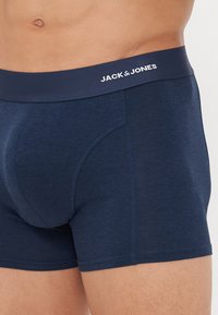 Marineblaue Boxershorts mit einem elastischen, gebrandeten Bund, der "JACK & JONES" in weißen Buchstaben trägt. Weicher Stoff mit passgenauer Passform.