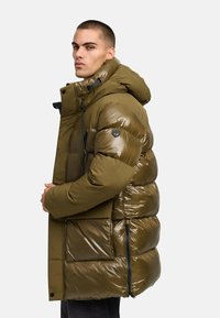 Olijfgroene pufferjack met een glanzende afwerking, grote capuchon en rits aan de voorkant. Heeft zijzakken en een logodetail op de mouw.