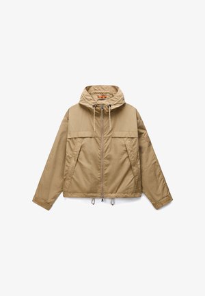 Beżowa lekka kurtka z kapturem, zapinana na zamek z przodu, z troczkami na kapturze i na dole, skośnymi przednimi kieszeniami oraz długimi rękawami z regulowanymi mankietami.