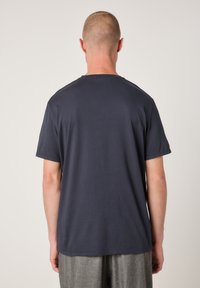 Navy blue t-shirt with a crew neck, short sleeves, and a relaxed fit. Soft fabric texture, no visible patterns or logos.