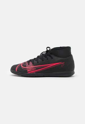 Czarny but do piłki nożnej na halę z różowym logo Nike i napisem "Mercurial", konstrukcja sięgająca do kostki i teksturowana podeszwa.