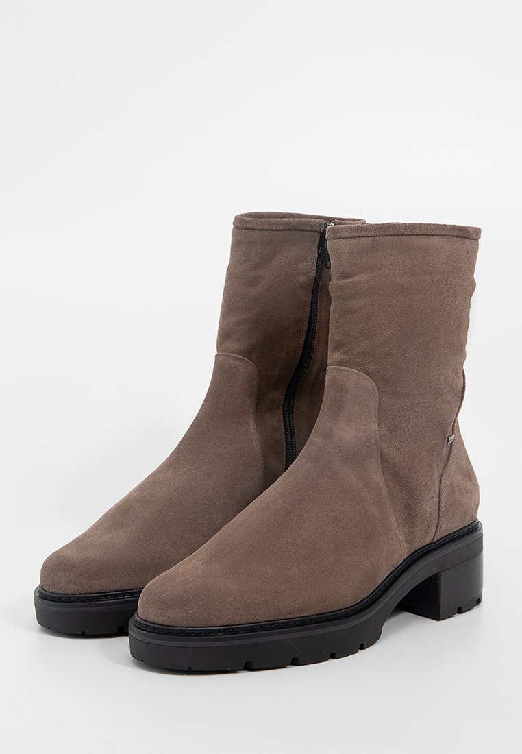 Braune Wildleder Stiefeletten mit runder Spitze, klobigem schwarzen Absatz und seitlichem Reißverschluss für ein einfaches Anziehen. Insgesamt glatte Textur.