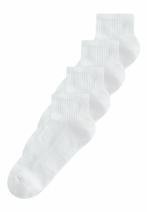Fire par almindelige hvide ankelhøje ribstrikkede sokker arrangeret diagonalt på en hvid baggrund.