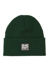 Zöld kötött sapka felhajtható szegéllyel, amelyen egy fekete-fehér téglalap alakú folt található, rajta a "HOMEBOY loud-couture" felirattal.