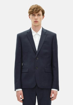 Chaqueta de traje azul marino con un diseño elegante, dos bolsillos frontales, solapas con muesca y dos botones negros; combinada con una camisa blanca debajo.