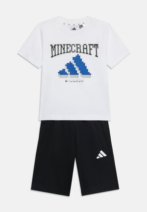 Wit T-shirt met korte mouwen met een gepixelde blauwe Adidas-logo en de tekst "MINECRAFT", gecombineerd met zwarte Adidas-short met een wit logo op het linkerbeen.