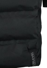 Zwarte pufferjack met een gladde, duurzame stof en een gequiltde textuur, met een logo-label aan de zijkant. Bekend ontwerp voor warmte en comfort.