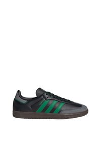 Black leather sneaker with three green stripes, textured gray toe cap, black laces, and a rubber sole featuring a herringbone pattern.
