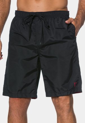 Black swim shorts made of lightweight fabric, featuring an elastic waistband with a drawstring, side pockets, and a small red logo detail.