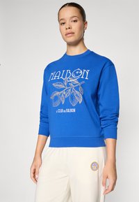 Felpa blu con grafica frontale contenente il testo "MALBON" e un design a foglia. Maniche lunghe e orlo a costine; materiale in morbido cotone.
