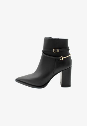 Stivaletto nero realizzato in materiale sintetico, con punta affusolata, tacco alto chunky e cinturino decorativo con accenti in hardware dorato.