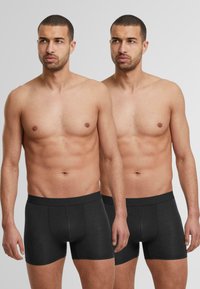 Boxer shorts noirs en coton avec une ceinture douce, design ajusté et sans motifs visibles. Deux modèles présentant la vue de face.