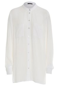 Camicia bianca a maniche lunghe con bottoni, realizzata in un tessuto leggero e texturizzato. Caratterizzata da un colletto alto e due tasche frontali. Bottoni argentati.