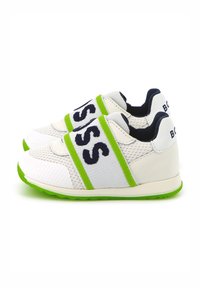 Witte sneakers met een ademend mesh bovenwerk en een groene rubberen zool, met marineblauwe branding op brede banden aan de voorkant.