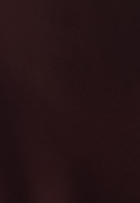 Ciemny burgundowy materiał o gładkiej, matowej teksturze, z równą powierzchnią bez wzorów lub widocznych detali sprzętowych.