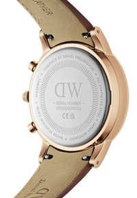 Orologio in acciaio inossidabile rosa con dettagli incisi, cinturino in pelle marrone e resistenza all'acqua fino a 5 ATM. Numero di serie incluso.