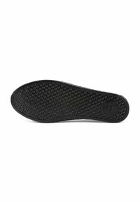 Semelle noire avec une surface texturée présentant de petits motifs circulaires pour l'adhérence, un bout arrondi et un bord lisse.
