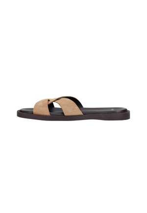 Bruine suède cross-strap slippers met zwart gewatteerd voetbed en platte donkerbruine zool, weergegeven vanaf de zijkant op witte achtergrond.
