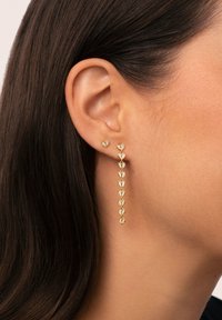 Orecchini in oro con pendenti a forma di cuore e un design a cascata con più motivi a cuore, decorati con accenti scintillanti.