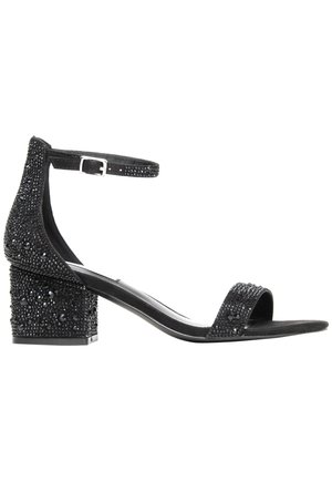 Schwarze Sandalen mit Absätzen, die einen Knöchelriemen tragen, geschmückt mit schwarzen Perlen und Strasssteinen sowie einem strukturierten Blockabsatz.