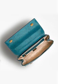Tealfärgad plånbok med ormskinnsmönster, med en slät yta, guldfärgad hårdvara och tygfoder med logotypmönster. Inkluderar ett fack med dragkedja på insidan.