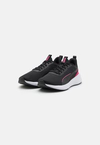 Zapatillas deportivas negras fabricadas con malla transpirable, con detalles en color rosa, suela blanca gruesa y diseño de cordones.