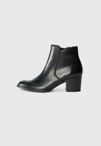 Botas de tobillo negras de cuero con punta redondeada, paneles laterales elásticos y un bajo tacón cuadrado. Textura lisa con un diseño elegante y minimalista.