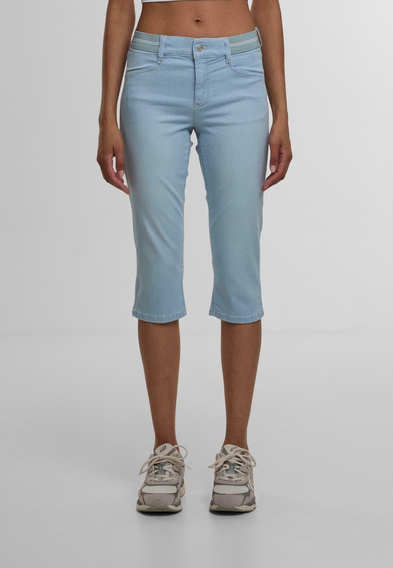 Capri in denim azzurro chiaro con una forma aderente, tasche standard e una leggera elasticità. Presenta una chiusura con zip e bottone.