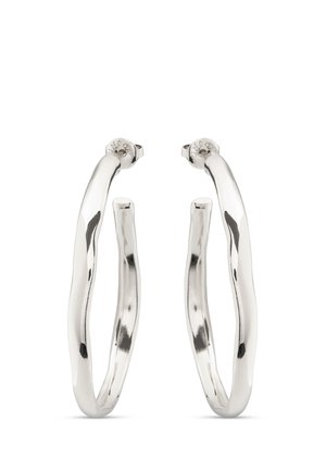 Coppia di orecchini a cerchio argentati lucidi con forme leggermente irregolari e ondulate e chiusure posteriori sicure su sfondo bianco.
