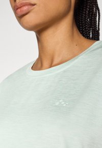 Μεντάς πράσινο μπλουζάκι από απαλό, υφασμάτινο με υφή, με στρογγυλή λαιμόκοψη και μικρή λογοτύπηση στον αριστερό θώρακα σε τονικό χρώμα.