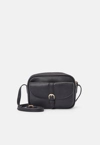 Bolso bandolera negro con textura, que presenta una solapa frontal con detalle de hebilla, cierre de cremallera y correa ajustable. Interior forrado suave, forma compacta.