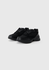 Black athletic shoes featuring a mesh upper and synthetic leather accents, rounded toe, thick sole, and textured tread for grip.