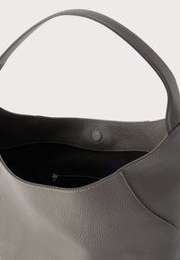 Geantă tote din piele gri, cu finisaj texturat, dotată cu un interior spațios și un buzunar cu fermoar. Design structurat moale și bretea lată.