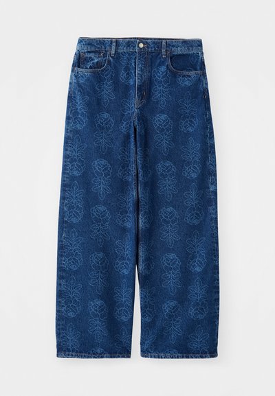 Jean en denim bleu à pattes d'éléphant, arborant un motif floral sur l'ensemble dans une teinte de bleu plus clair, avec une conception traditionnelle à cinq poches et un bouton en métal.
