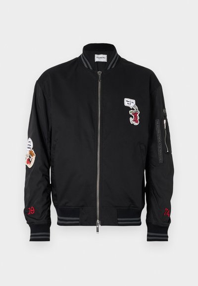 Juodas bomber tipo švarkas su nertomis apykakle ir rankovėmis, dekoruotas siuvinėjimais ant krūtinės ir rankovių, taip pat raudonais akcentais ant rankovių.