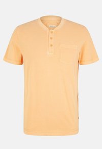 Kortærmet henley-stil t-shirt i blød orange bomuld. Har tre knaplukninger, rund halsudskæring og en brystlomme.